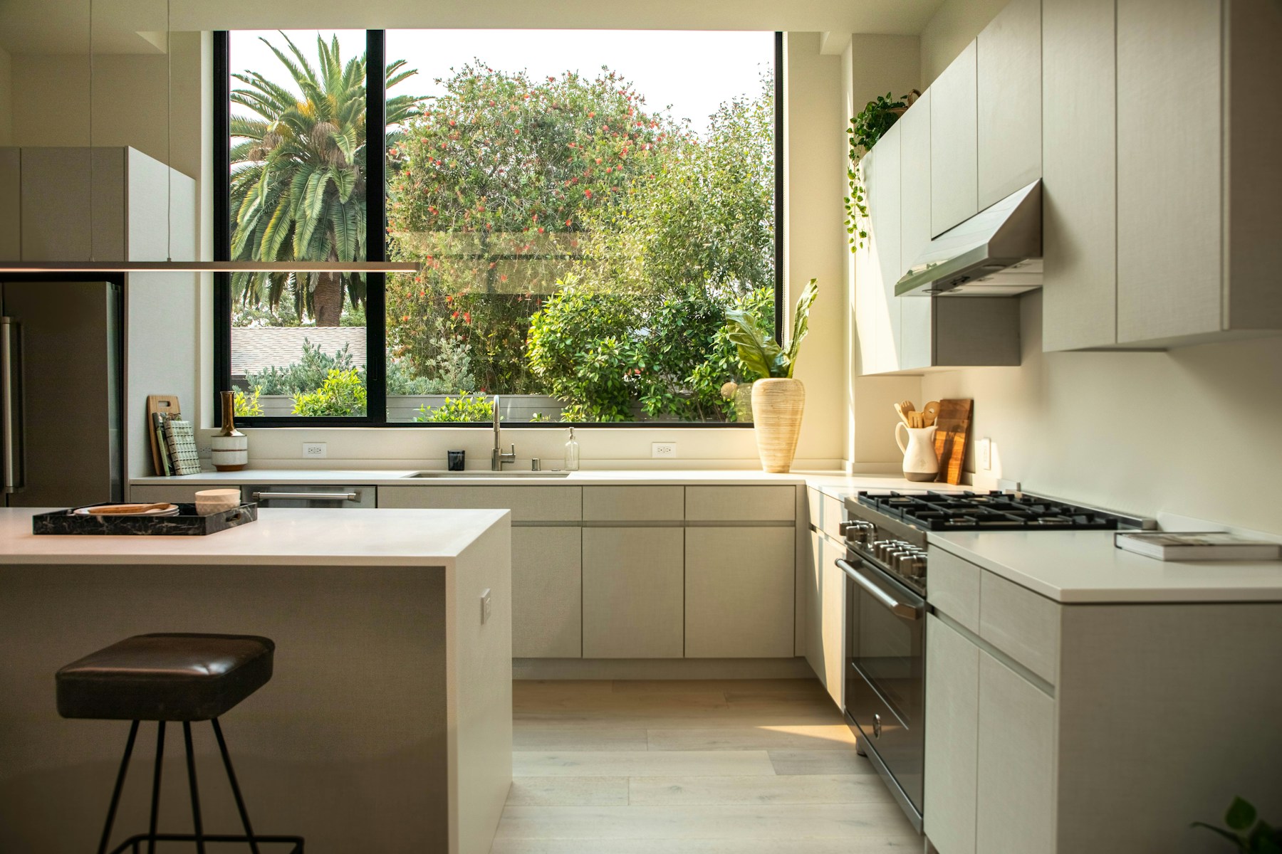 Contemporary white kitchen with an island and garden view